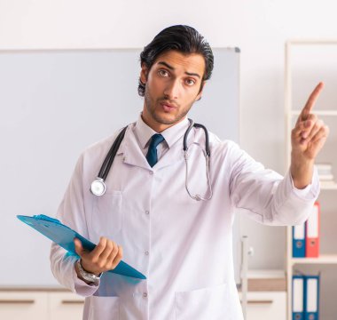 Beyaz tahtanın önündeki genç doktor.