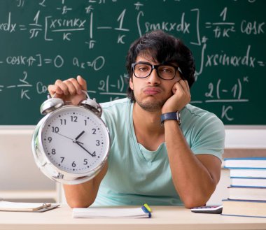 Tahtanın önündeki genç erkek matematikçi.