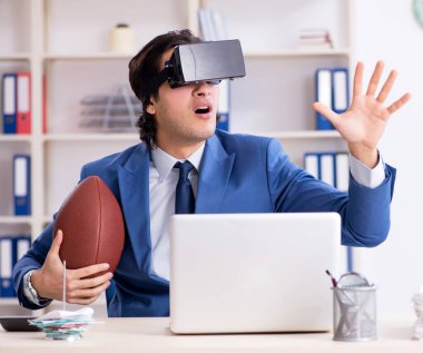 The young handsome businessman playing rugby with virtual glasses