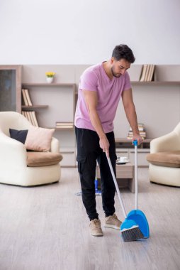 Genç müteahhit evi temizliyor.