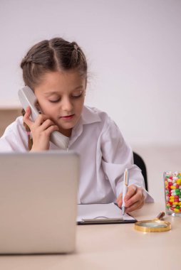 Little girl playing doctor in telemedicine concept