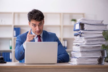 Young employee and too much work at workplace