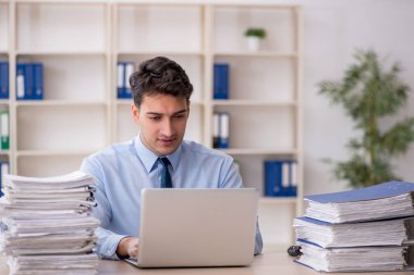 Young employee and too much work at workplace