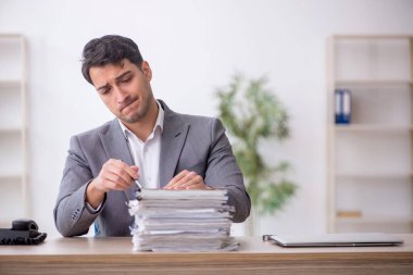 Young employee and too much work at workplace