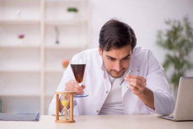 Laboratuvarda alkolsüz içeceği inceleyen genç bir kimyager.