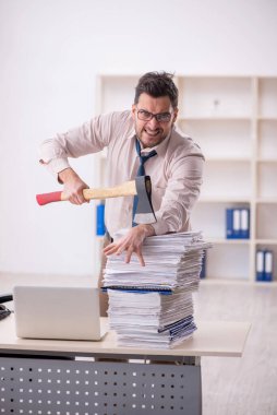 Young employee and too much work at workplace