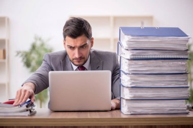 Genç bir çalışan ve ofiste çok fazla iş var.