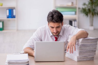 Ofisteki aşırı işten memnun olmayan genç bir çalışan.