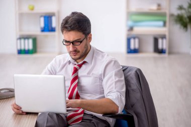 Ofisteki aşırı işten memnun olmayan genç bir çalışan.