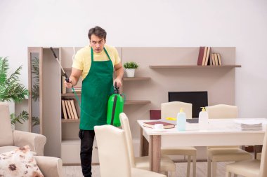 Genç adam evi temizliyor.