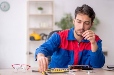 Laboratuvarda bilgisayar tamir eden genç bir tamirci.