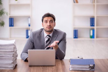 Genç bir çalışan ve ofiste çok fazla iş var.