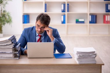 Genç işadamı işyerinde oturuyor.