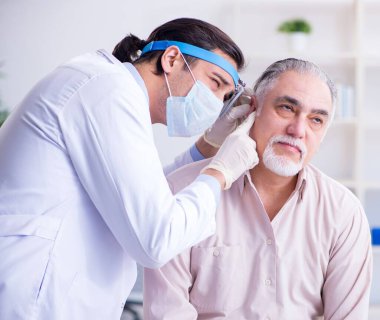 Erkek hasta doktor otolaringolojisti ziyaret ediyor.