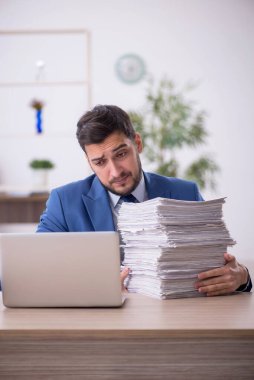 Genç bir çalışan ve ofiste çok fazla iş var.