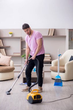 Genç müteahhit evi temizliyor.