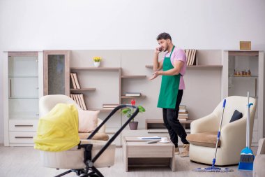 Yeni doğan bebeğe bakan genç bir müteahhit.