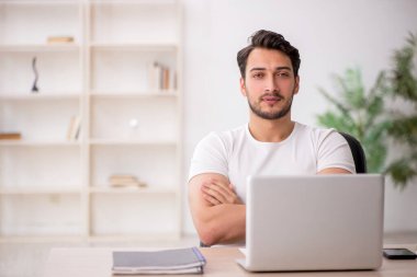 Genç çalışan işyerinde oturuyor.