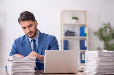 Young employee and too much work at workplace