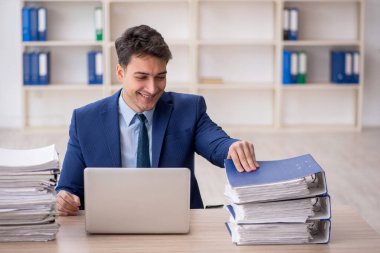 Young employee and too much work at workplace