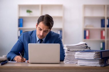 Genç işadamı ve ofiste çok fazla iş var.