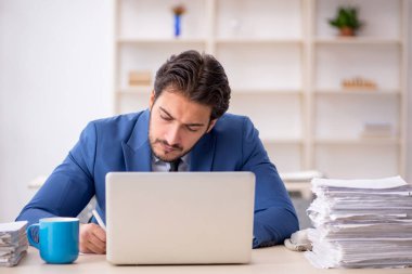 Genç işadamı ve ofiste çok fazla iş var.