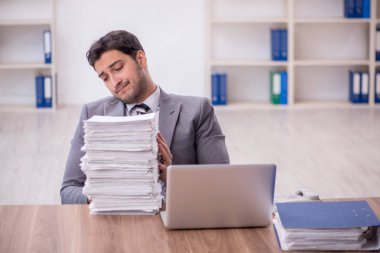 Genç bir çalışan ve ofiste çok fazla iş var.