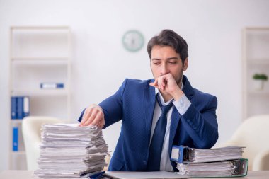 Young employee and too much work at workplace