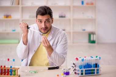 Young chemist sitting at the lab
