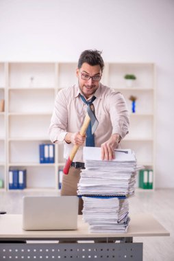 Young employee and too much work at workplace