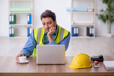 Genç mimar molada kahve içiyor.