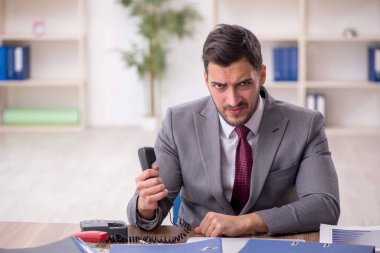 Genç bir çalışan ve ofiste çok fazla iş var.