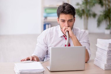 Ofisteki aşırı işten memnun olmayan genç bir çalışan.