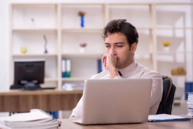 Genç işadamı ve işyerinde çok fazla iş var.