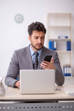 Genç bir çalışan ve ofiste çok fazla iş var.