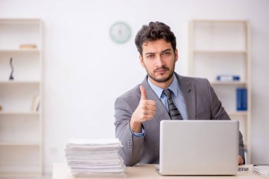 Genç bir çalışan ve ofiste çok fazla iş var.