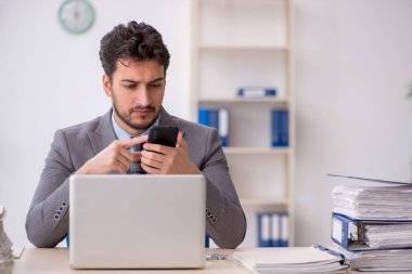 Genç bir çalışan ve ofiste çok fazla iş var.