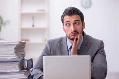 Genç bir çalışan ve ofiste çok fazla iş var.