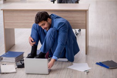 Young employee unhappy with excessive work at workplace