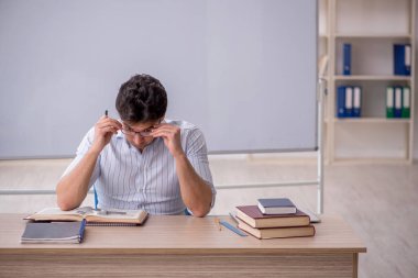 Beyaz tahtanın önünde genç öğretmen.