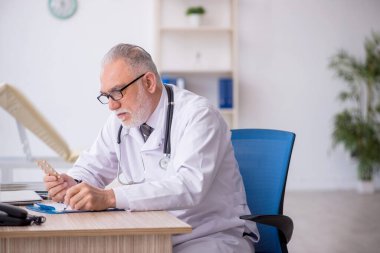 Old doctor suggesting pills at the hospital