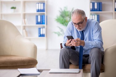 Ofiste telefonla konuşan eski bir çalışan.