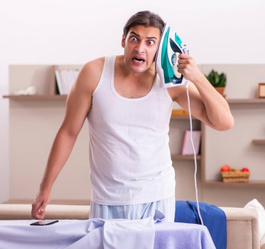 Genç çalışan sabah ütü yapıyor.