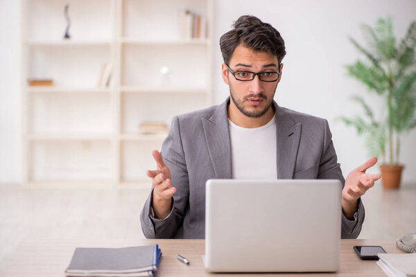 Young employee sitting at workplace