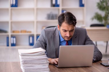 Genç işadamı işyerinde oturuyor.