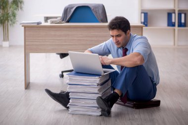 Young employee unhappy with excessive work at workplace