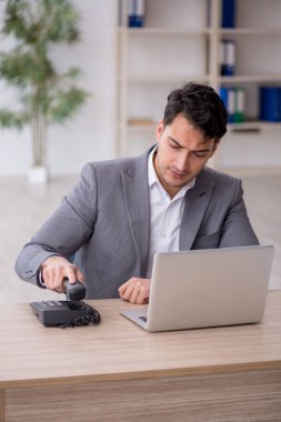 Young employee and too much work at workplace