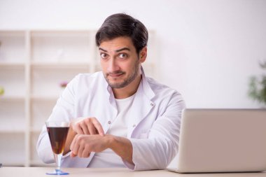 Laboratuvarda alkolsüz içeceği inceleyen genç bir kimyager.