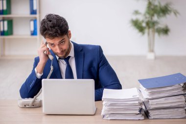 Ofisteki aşırı işten memnun olmayan genç bir çalışan.