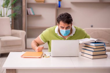 Genç öğrenci salgın sırasında evde sınavlara hazırlanıyor.